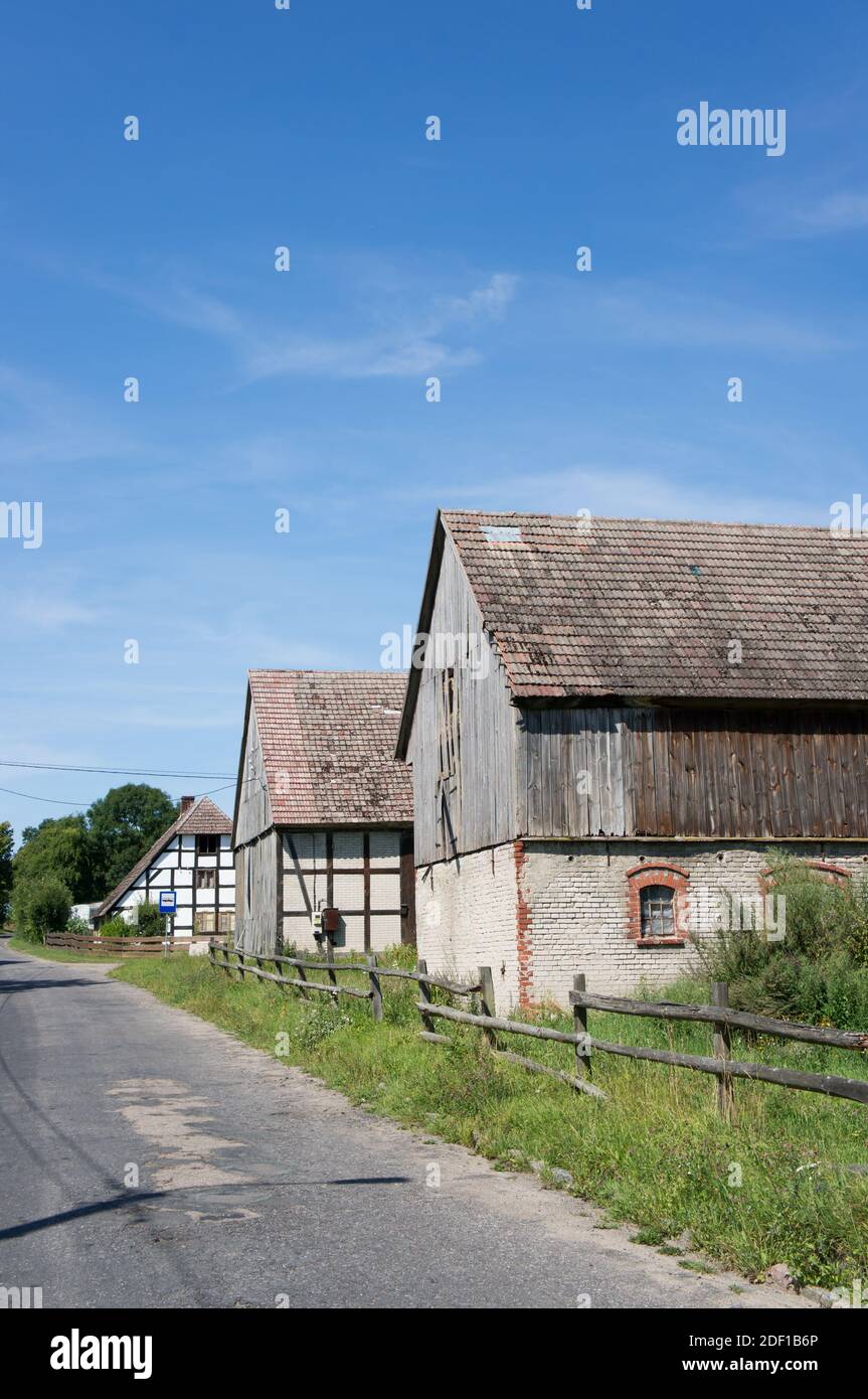 The old houses made of wood near the road under the blue sky Stock