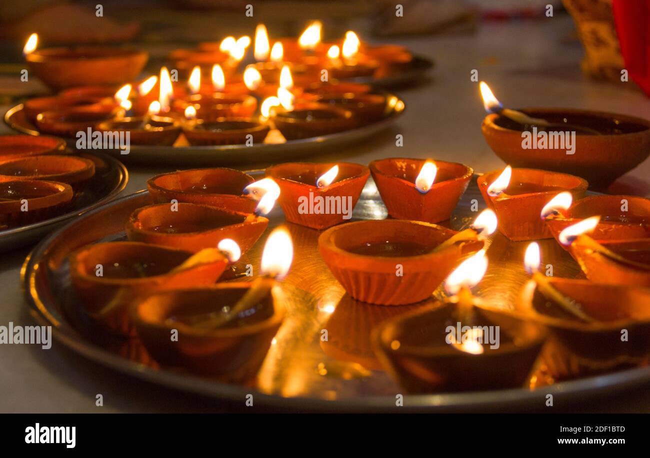 Lighting candles and clay lamps on silver trays for Diwali Hindu