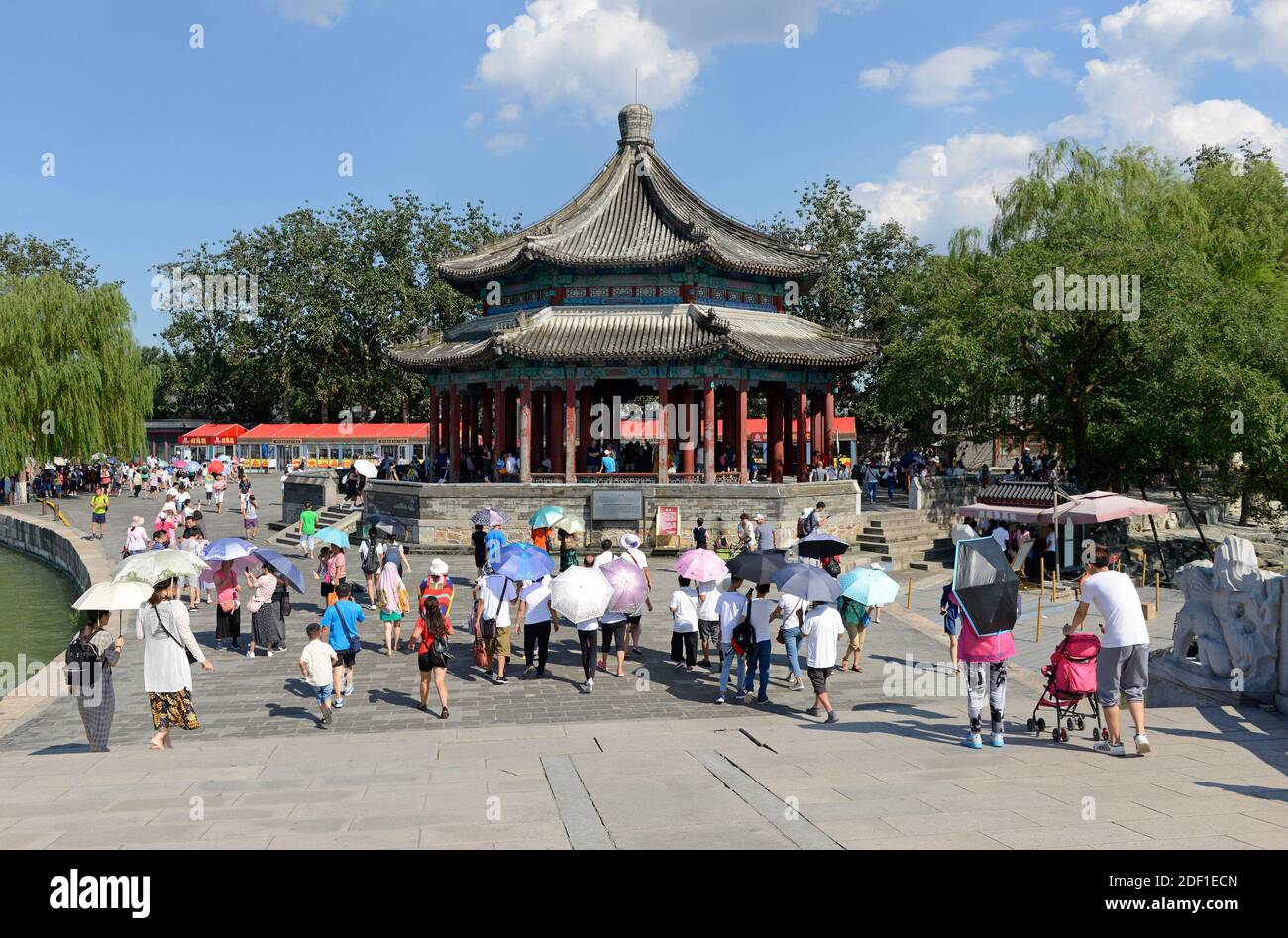Many visitors at the Kuoru pavilion at the eastern end of the seventeen arch bridge in the Summer Palace compound in Beijing, China Stock Photo
