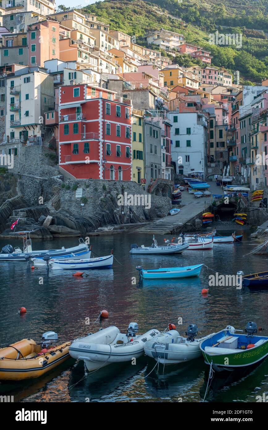 Boats line up, front of the colorful Riomaggiore village, Cinque Terre Stock Photo