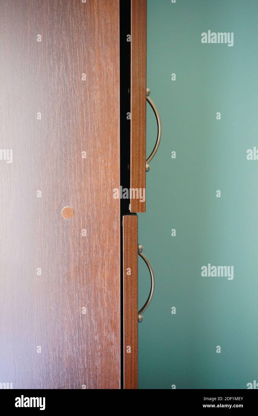 A closeup of a wooden door of a cupboard with small opening Stock Photo