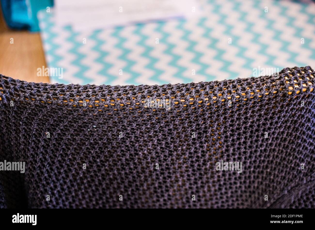 A dark fabric on a chair in front of the carpet with green patterns Stock Photo