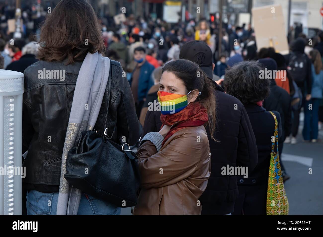 Paris, France - November 28th 2020 : at the march against the global security law, woman weraing a rainbow mask looking at the procession Stock Photo