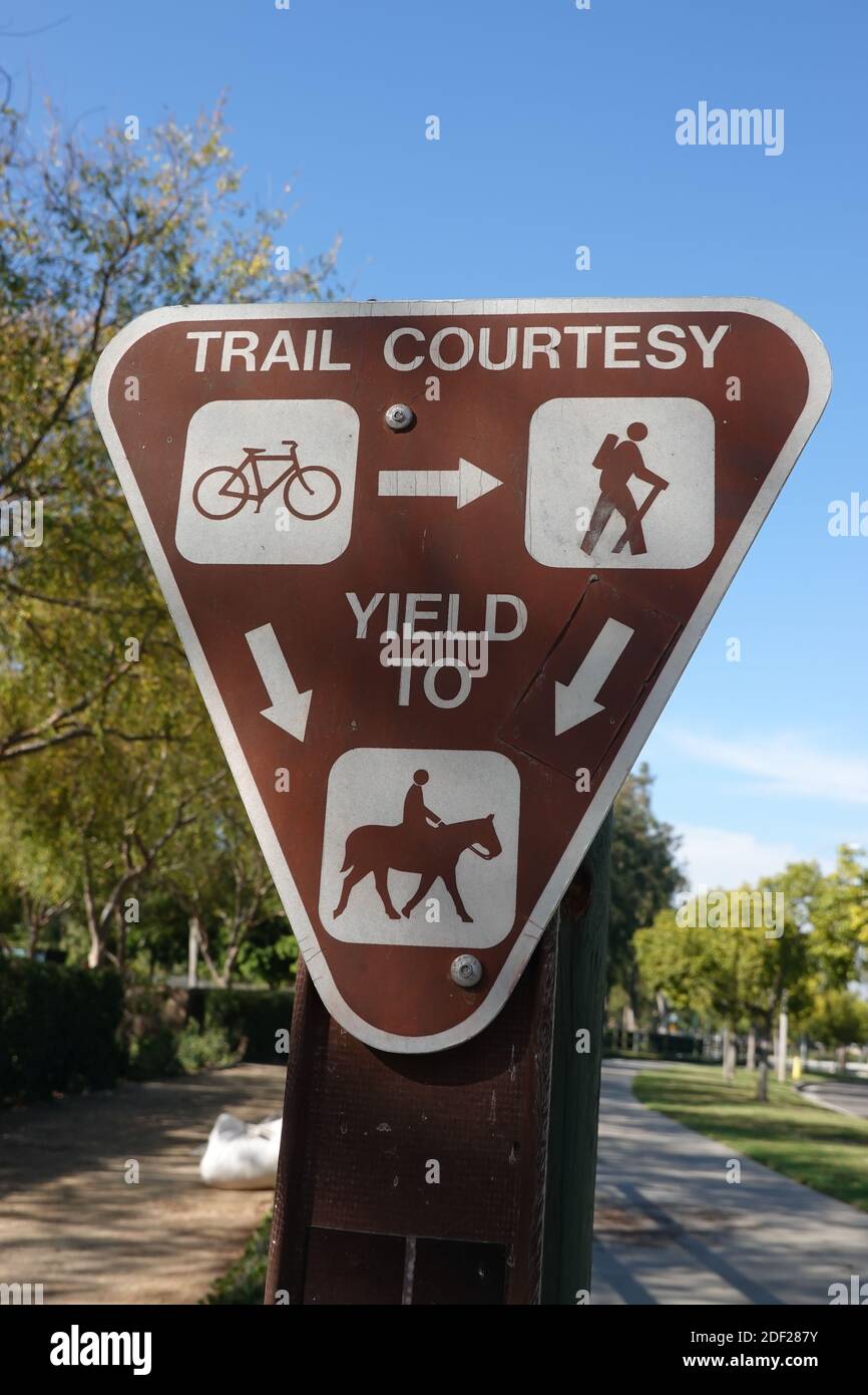 Trail Courtesy sign for hikers, pedestrians, walkers, cyclists, and horses. trail etiquette . On a trail in the city of Irvine , California, USA Stock Photo