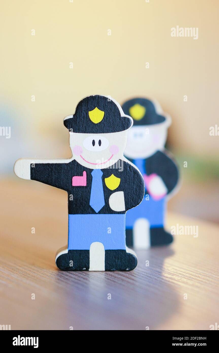 A vertical shot of wooden policemen toy on a table Stock Photo