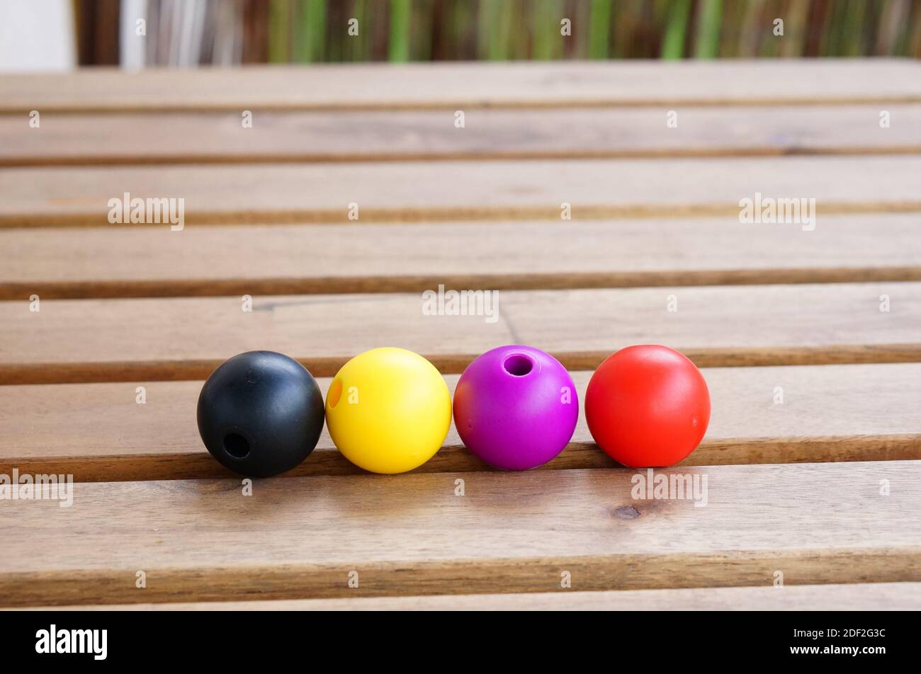 Four round objects of black, yellow, purple and red colors Stock Photo ...