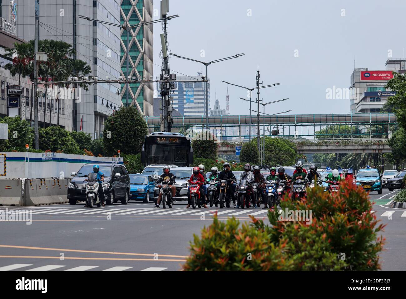 Jakarta, Indonesia - 25 October 2020. Motorcyclists and cars stopped at traffic lights Stock Photo