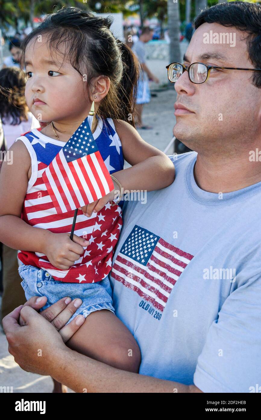 Miami Beach Florida,Ocean Drive,Lummus Park,4th of July Celebration citizenship ceremony naturalization,Asian girl man holding daughter, Stock Photo