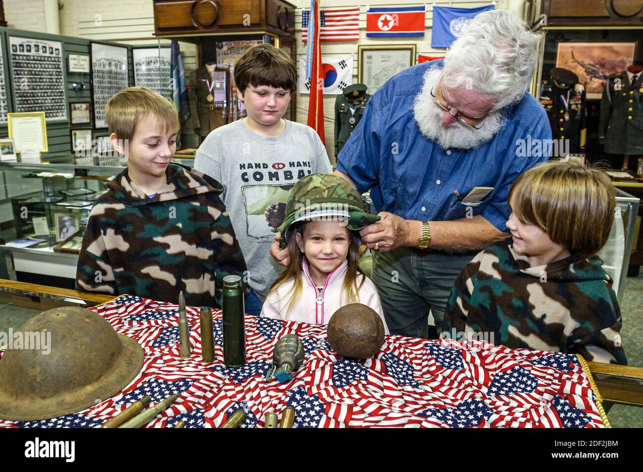 Alabama Athens Alabama Veteran's Museum & Archives,exhibits collection helmets ammunition shells,boys girl kids children,look looking man guide explai Stock Photo