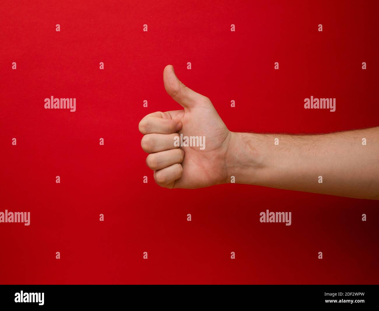 Female hand shows thumb up gesture on a background Stock Photo