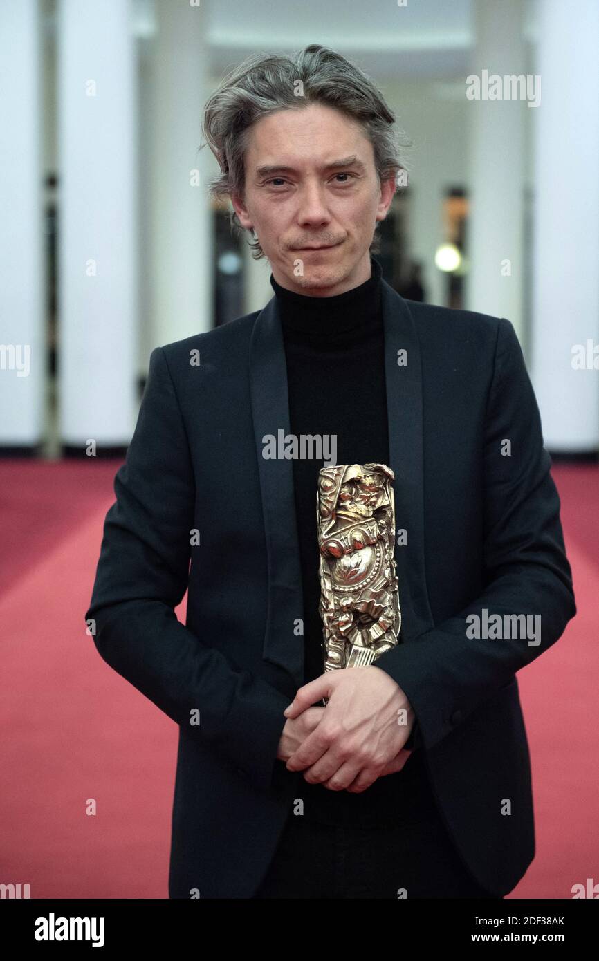 Swann Arlaud poses with the Best Actor in a Supporting Role Award for