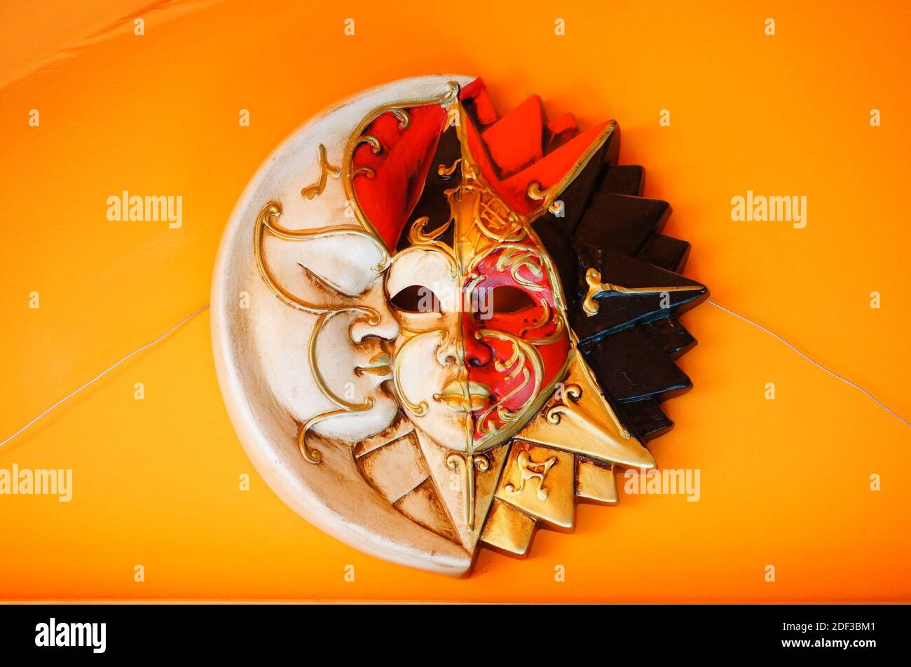 A dramatic theater mask isolated on the orange background Stock Photo