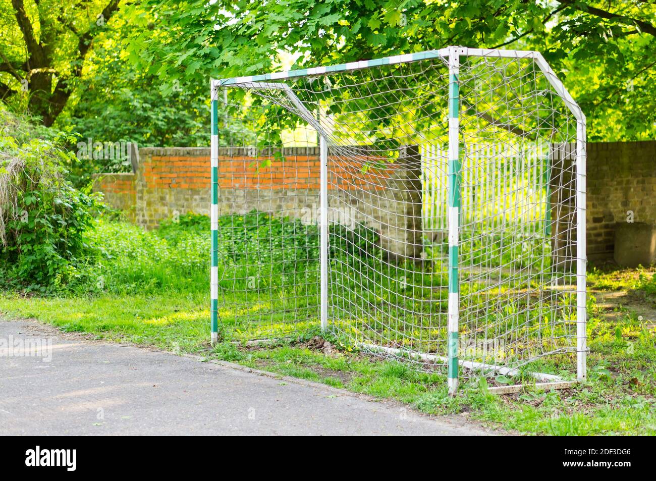 A ball gate in a football field in the park surrounded by green trees ...