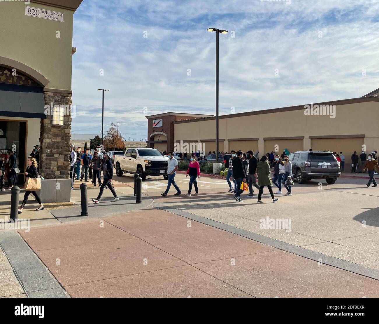 Allen, TX / USA - November 27, 2020: A view of people wearing the mask and carrying the shopping bags walking at the Allen Premium Outlets on Black Fr Stock Photo