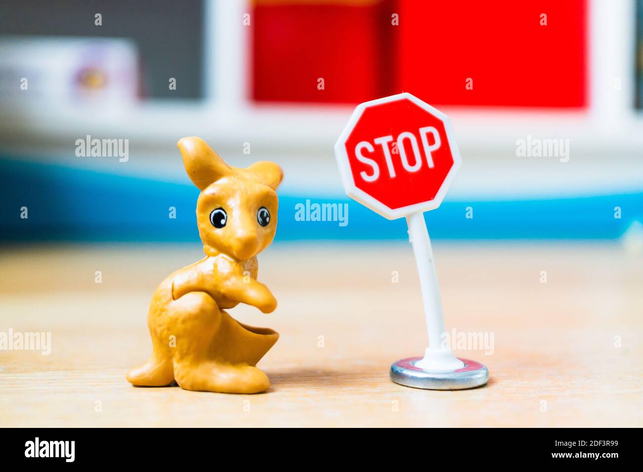 POZNAN, POLAND - Feb 15, 2019: Plastic toy kanagaroo figurine and a stop board in soft focus background. Stock Photo