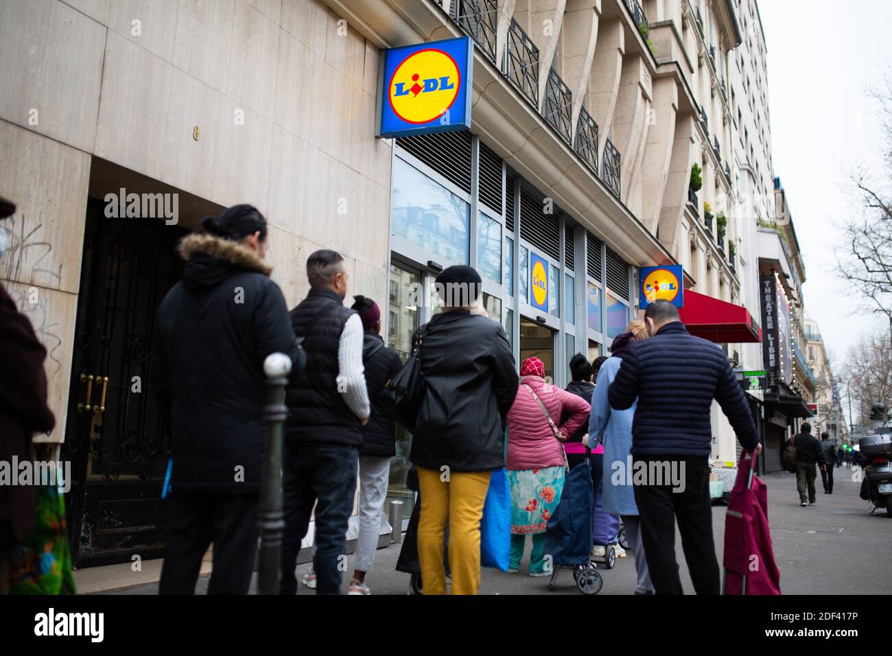 People queue to enter a supermarket ( Lidl ), as only 30 people are allowed  in at the same time, on March 16, 2020 in Paris, while protective measures  are taken in