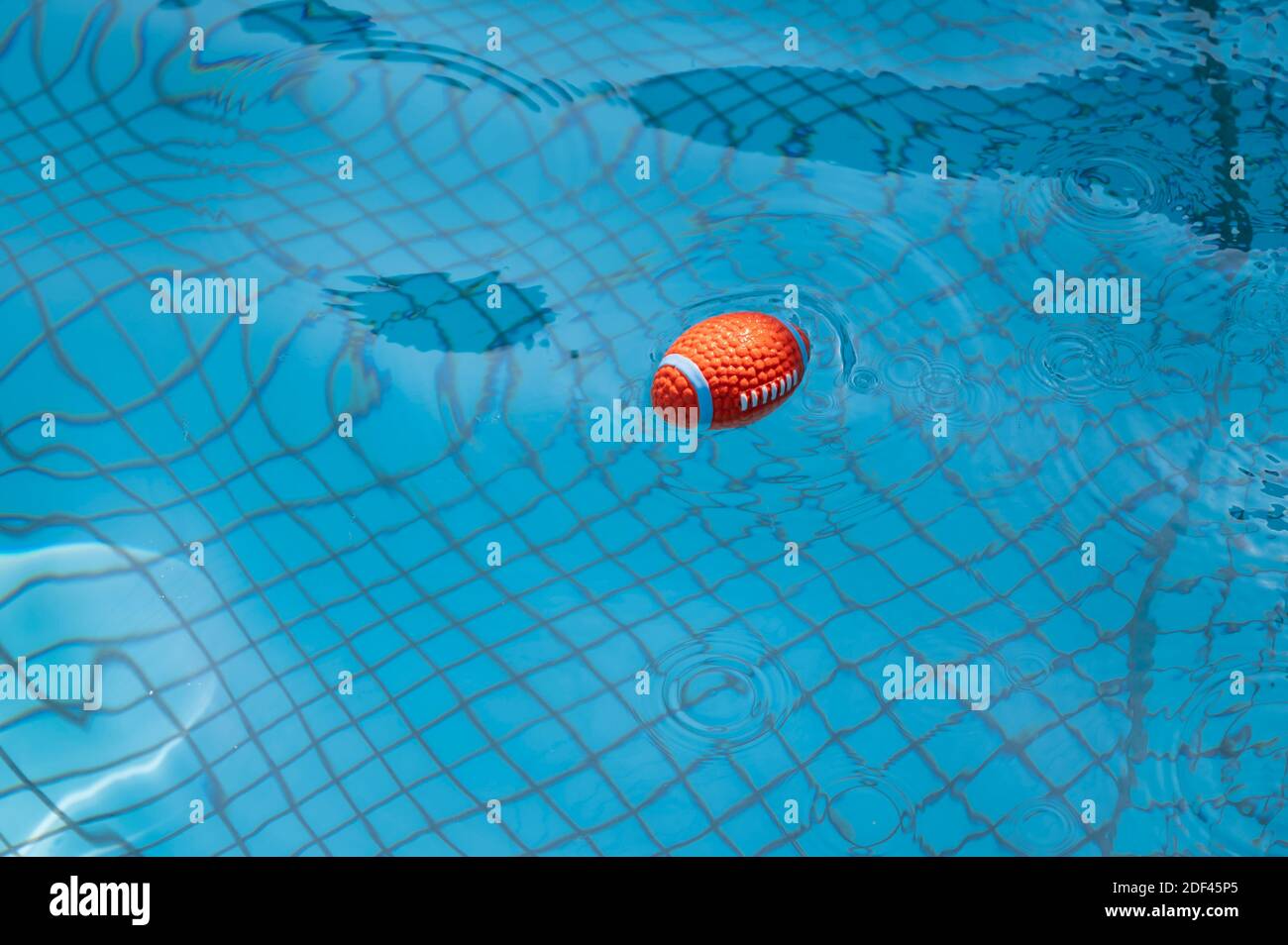 Toy ball floating on the pool water Stock Photo