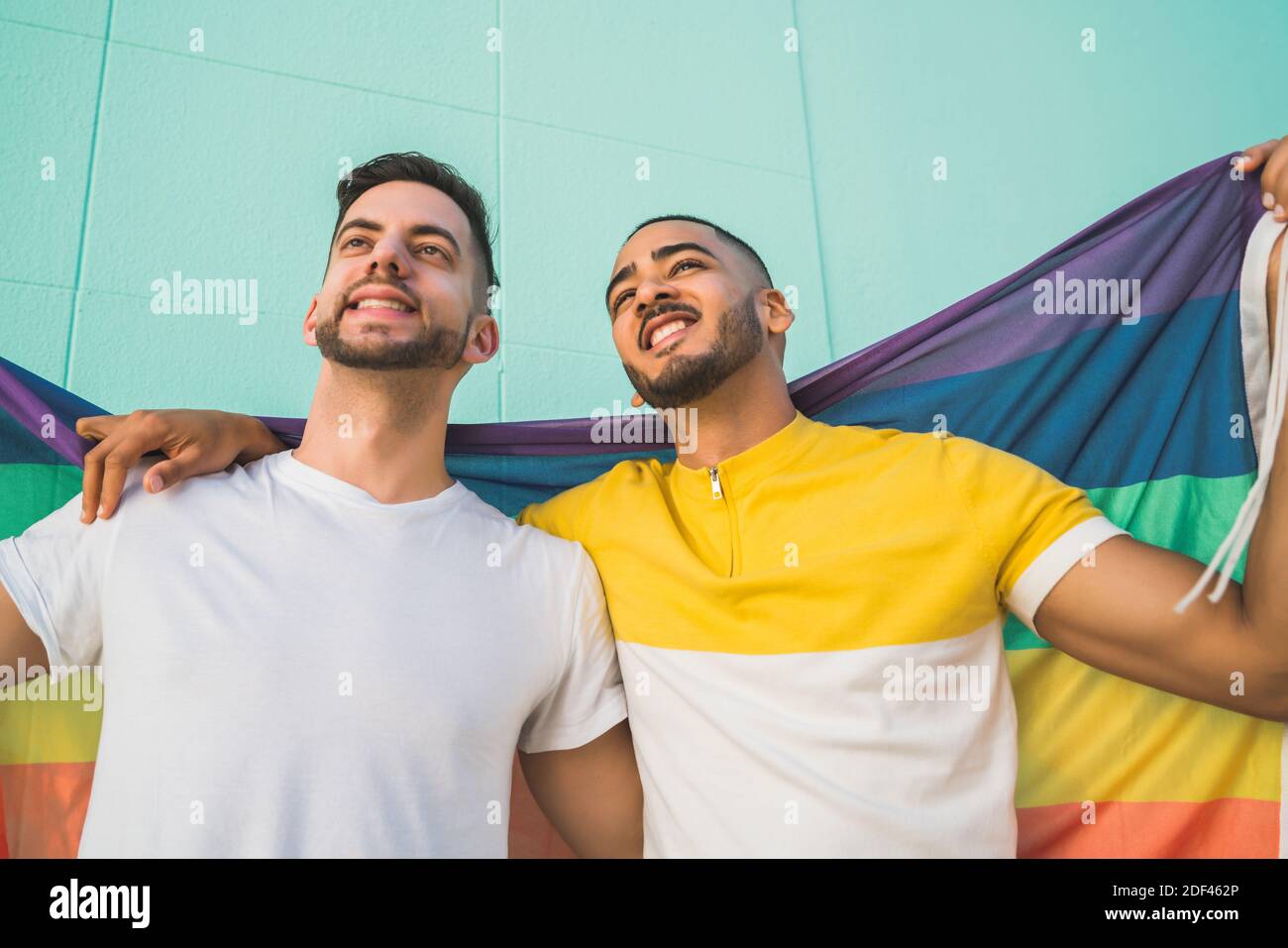 Gay couple embracing and showing their love with rainbow flag Stock ...