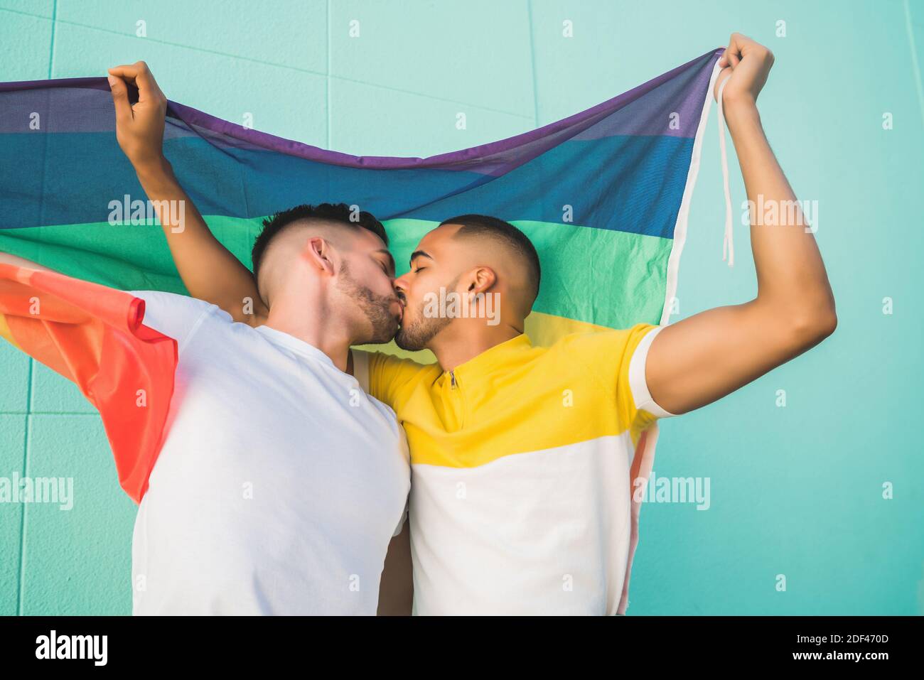 Gay couple embracing and showing their love with rainbow flag Stock ...