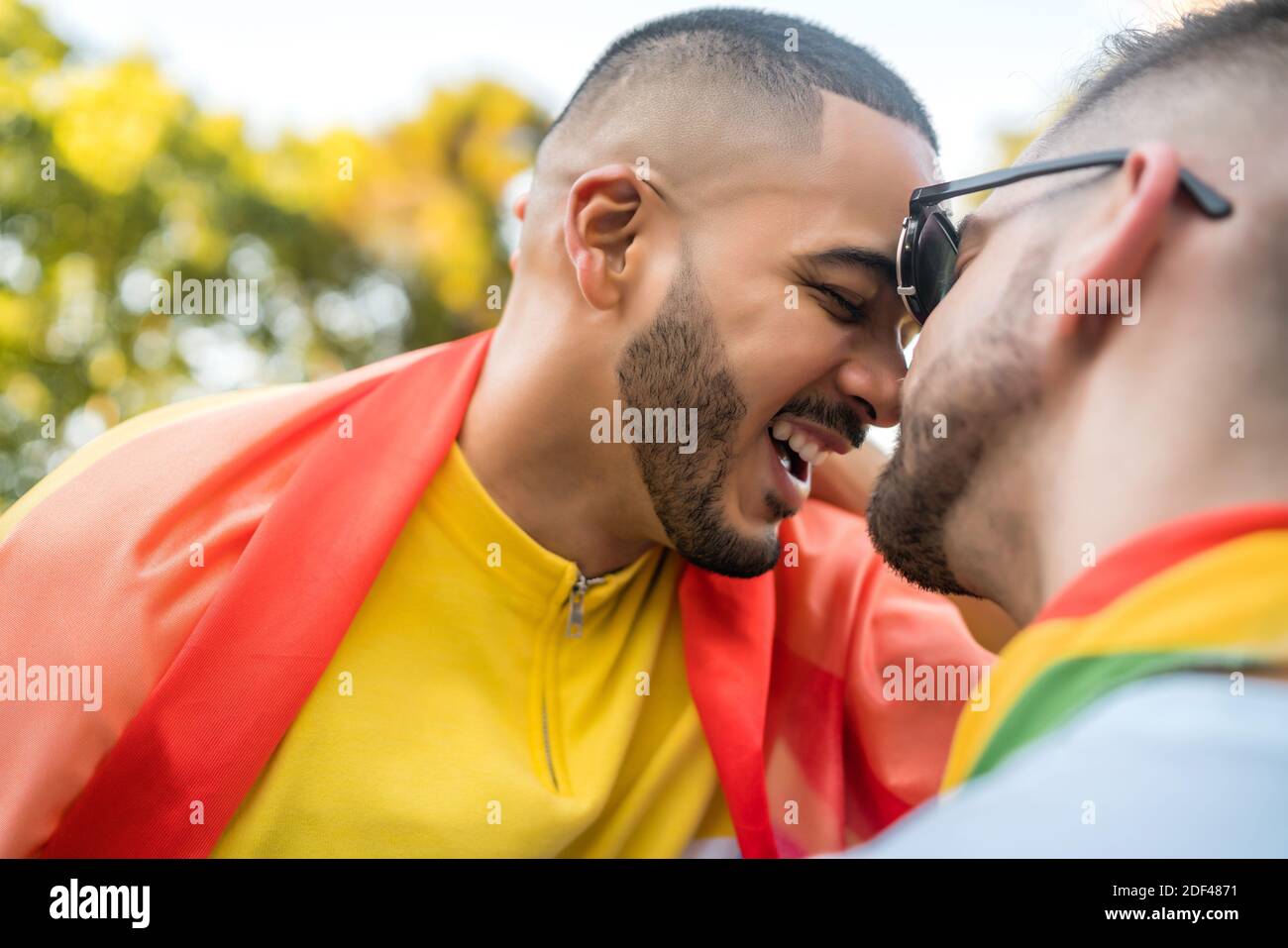 Gay couple embracing and showing their love with rainbow flag Stock ...