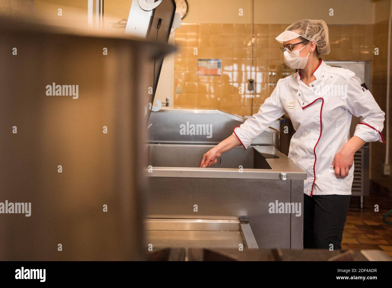 A cooker wearing a mask prepares food on March 27, 2020 in Marchiennes ...