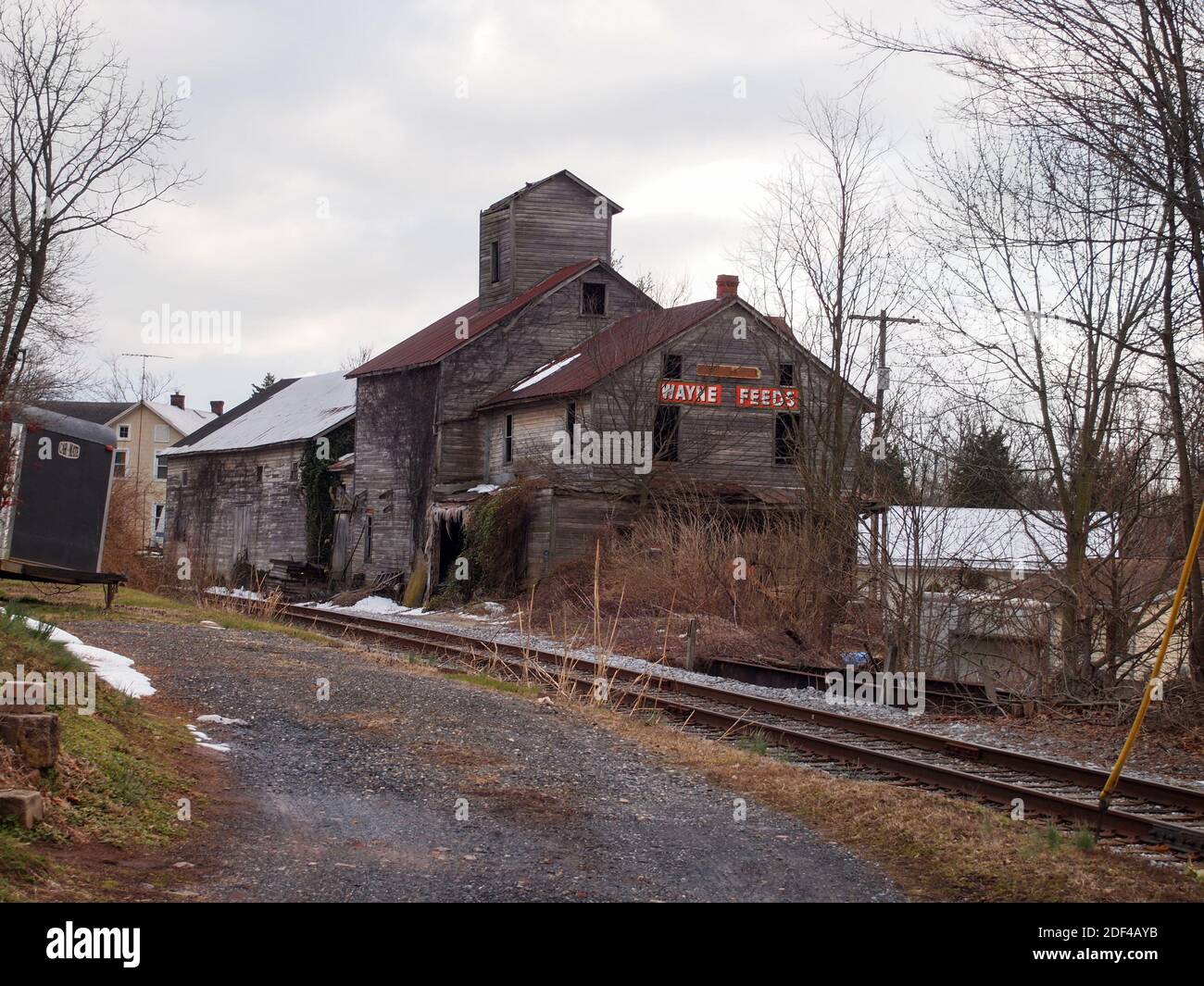 DETOUR, MARYLAND - MARCH 19, 2017: A vintage 1800”s feed mill, the Detour Feed Mill, long out of operation, sits abandoned next to the train tracks in Stock Photo