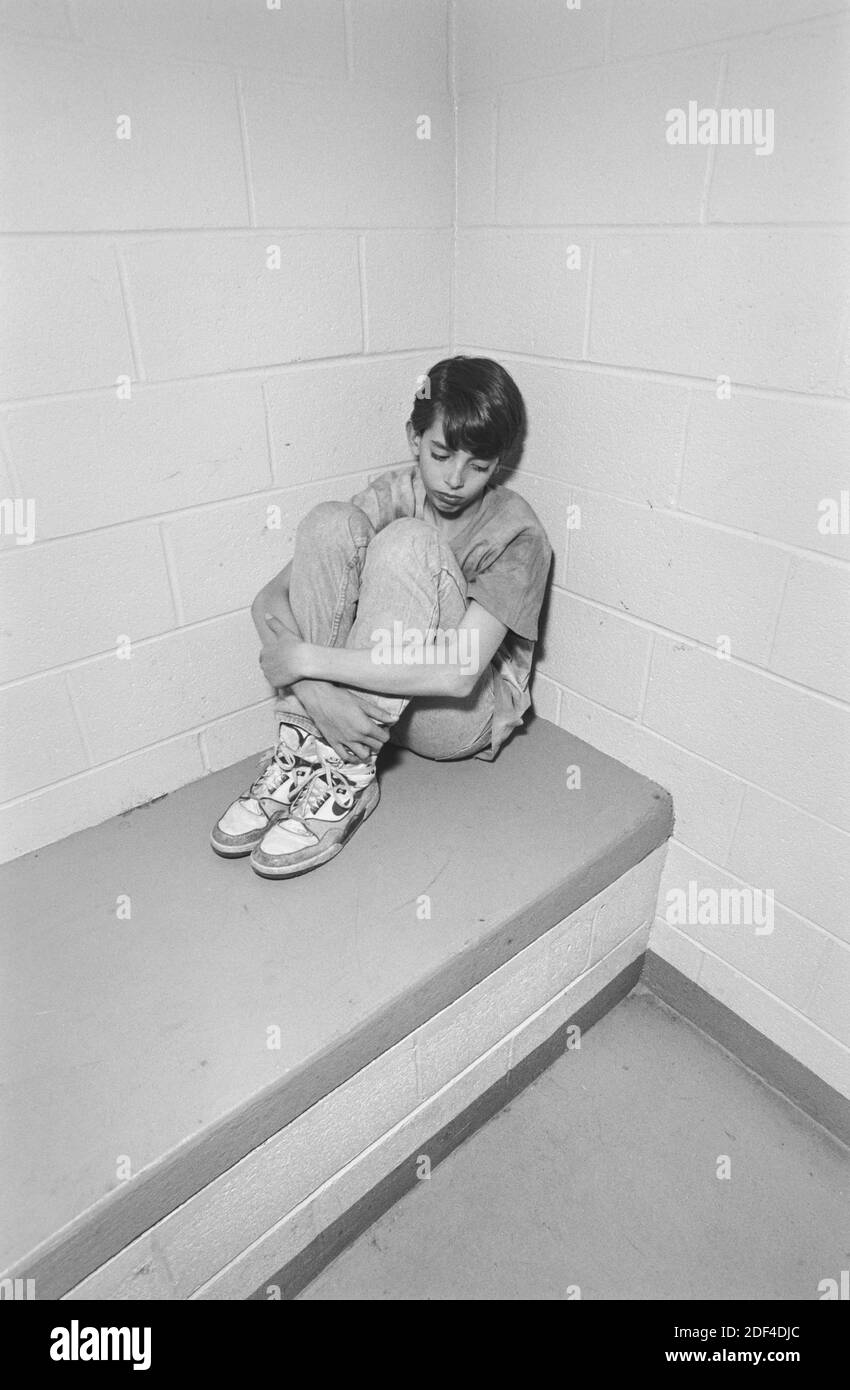 A young boy in a detention cell at a juvenile detention center.  ** THE BOY IS A COMPENSATED MODEL . MODEL RELEASED ** Stock Photo