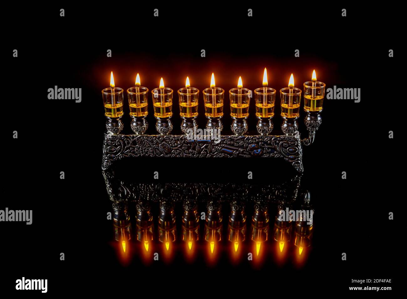 Menorah with burning oil candles with reflection for Hanukkah jewish