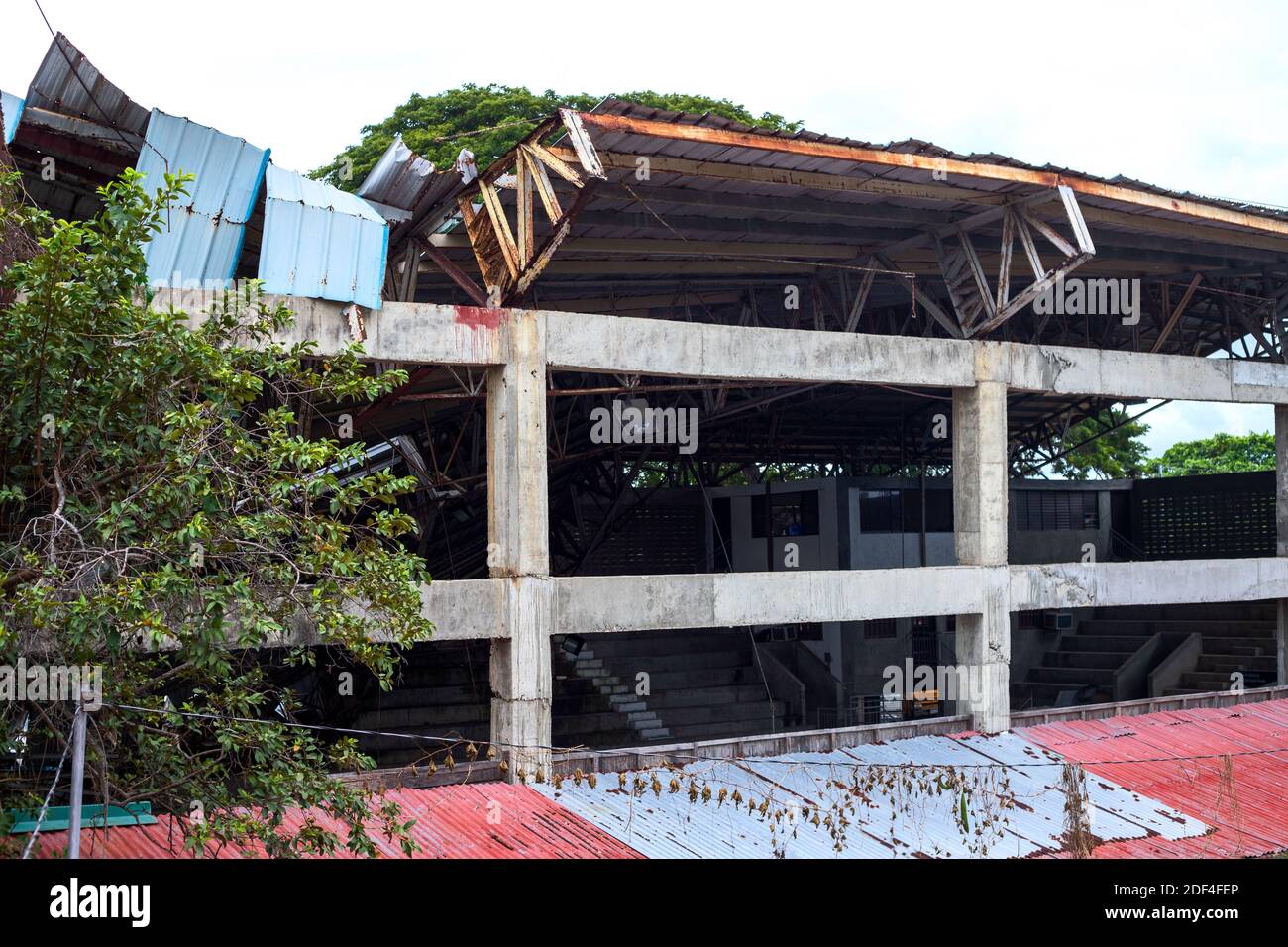Ruined sport stadium after typhoon, South Asia natural disaster. Earthquake or storm impact on small town economy. Ruined building by severe weather. Stock Photo