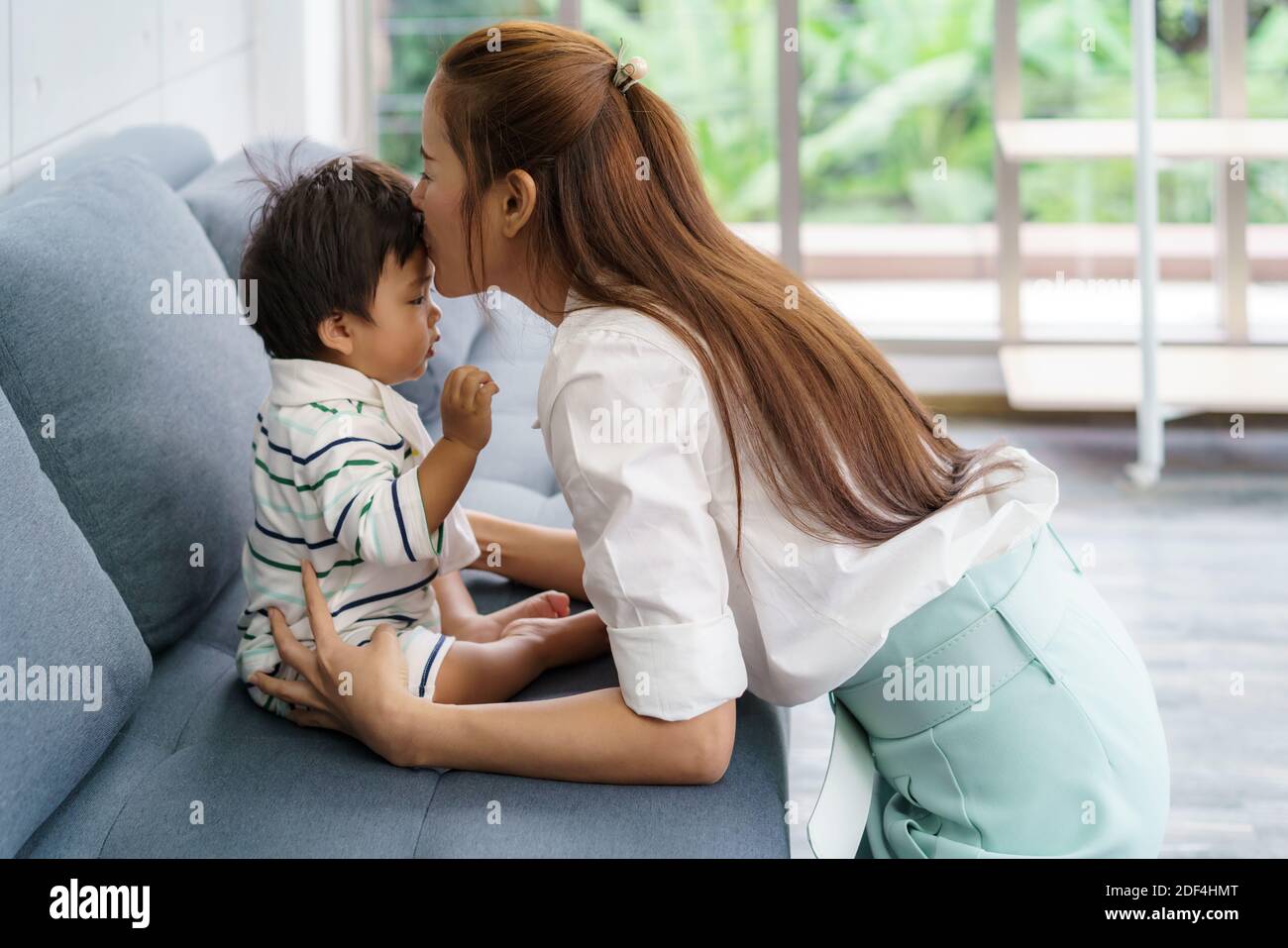 Close up portrait of beautiful young asian mother kissing her newborn baby to love asia woman lifestyle mother's day concept with copy space. Stock Photo