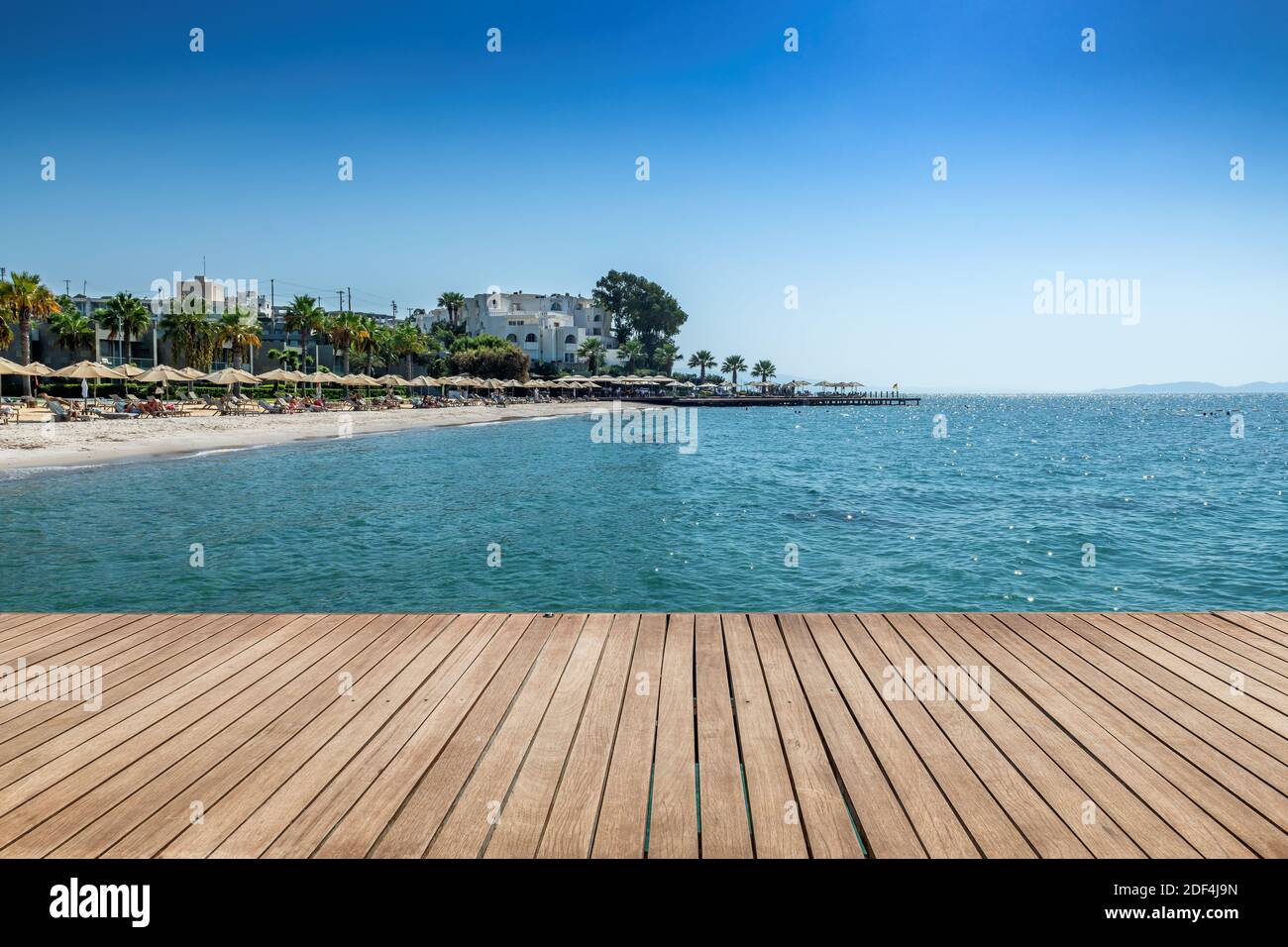 Wooden floor on a sea pier and beautiful beach resort on Mediterranean sea Stock Photo