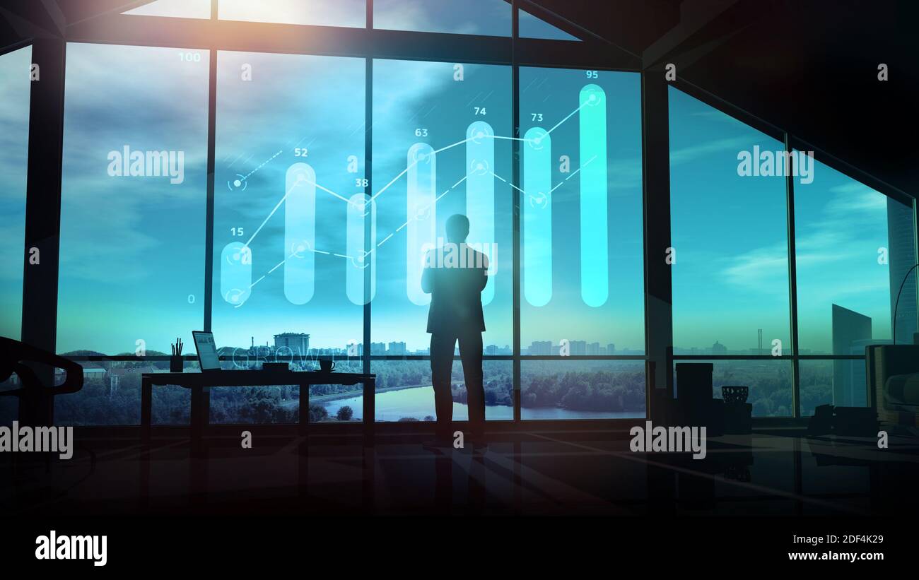 Businessman looks at the growth graph in the evening office. Stock Photo