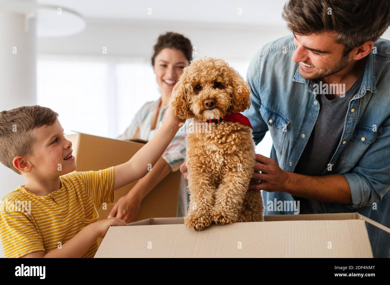 Happy family unpacking boxes in new home on moving day Stock Photo