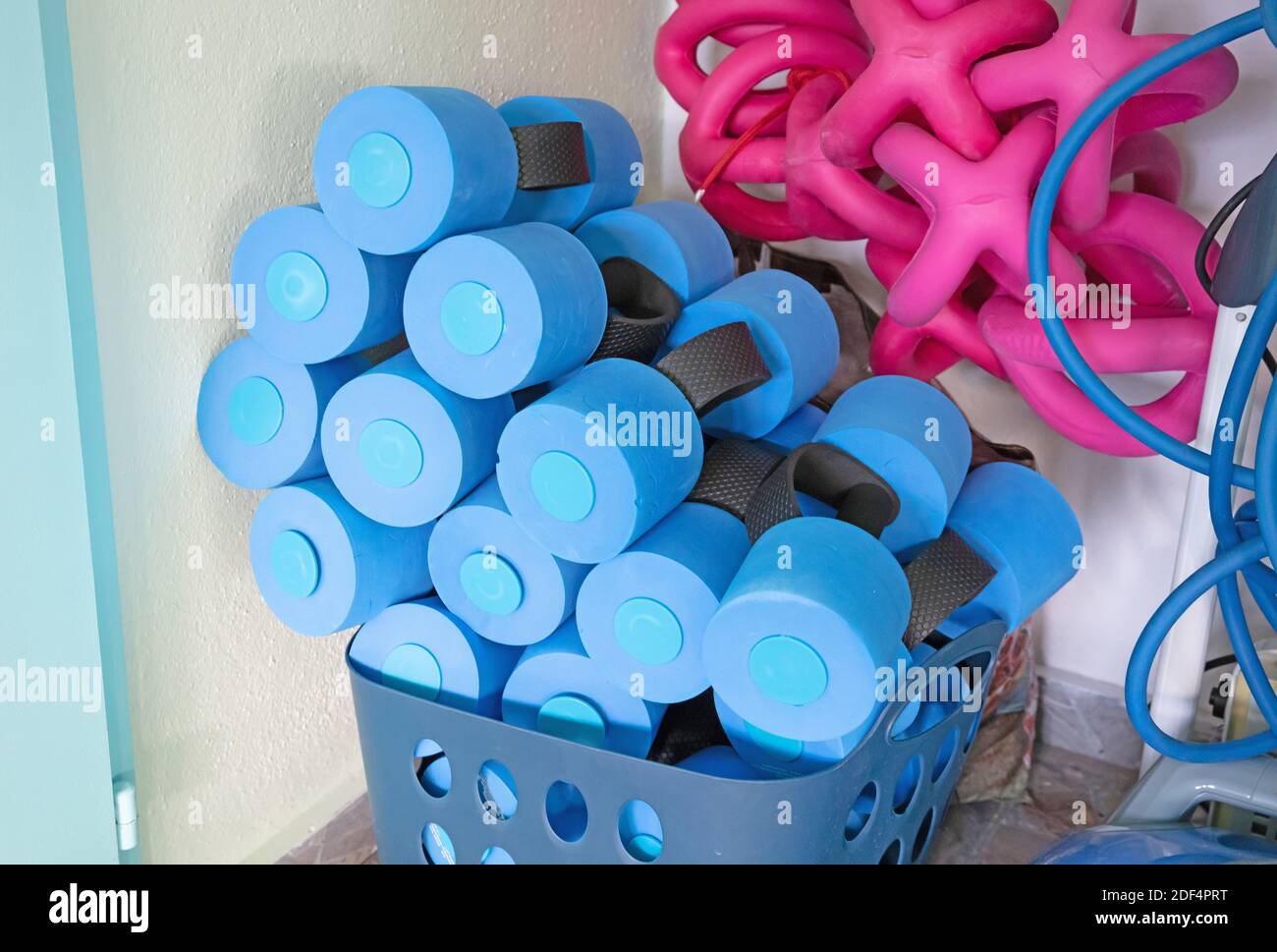Blue dumbbell weights for water aerobics by the poolside Stock Photo