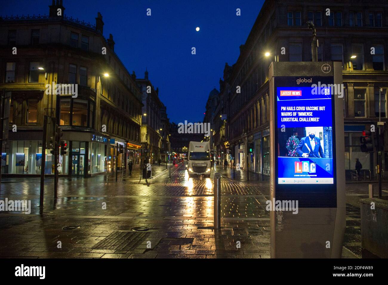 Glasgow, Scotland, UK. 3rd Dec, 2020. Pictured: Gordon Street with a live news notice from LBC advising, “PM HAILS COVID VACCINE BUT WARNS OF ‘IMMENSE LOGISTICAL CHALLENGES'” Scenes in Glasgow city centre at what should be a busy time with commuters going places, the first snow has fallen over night the city centre is free ion snow) however this has had an impact on travel making the city centre very quiet and empty. Credit: Colin Fisher/Alamy Live News Stock Photo