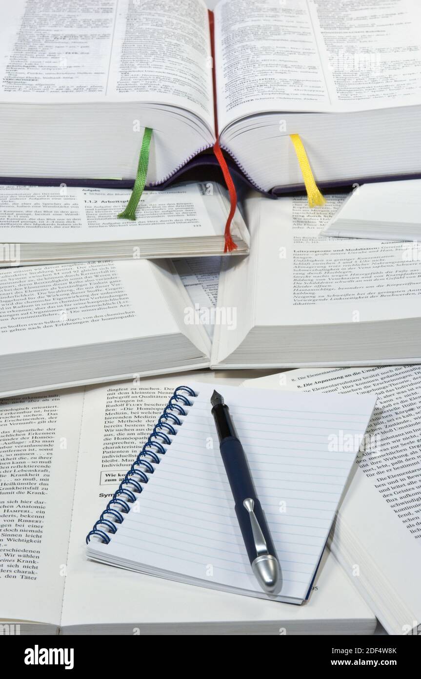 Bücherstapel mit leerem Notizblock und Federhalter Stock Photo