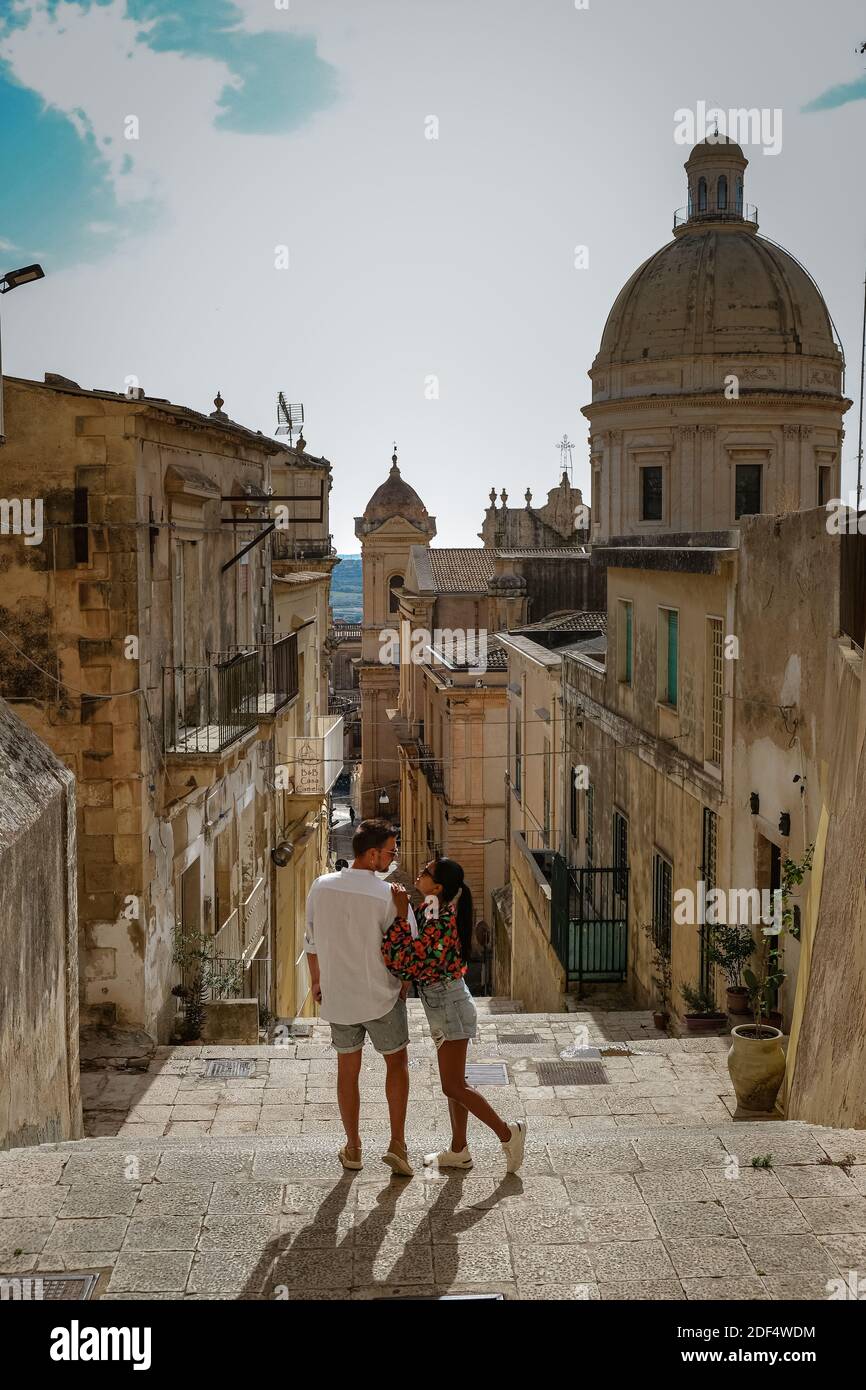 Sicily Italy, view of Noto old town and Noto Cathedral, Sicily, Italy. beautiful and typical streets and stairs in the baroque town of Noto in the province of Syracuse in Sicily, a couple on city trip Noto Stock Photo