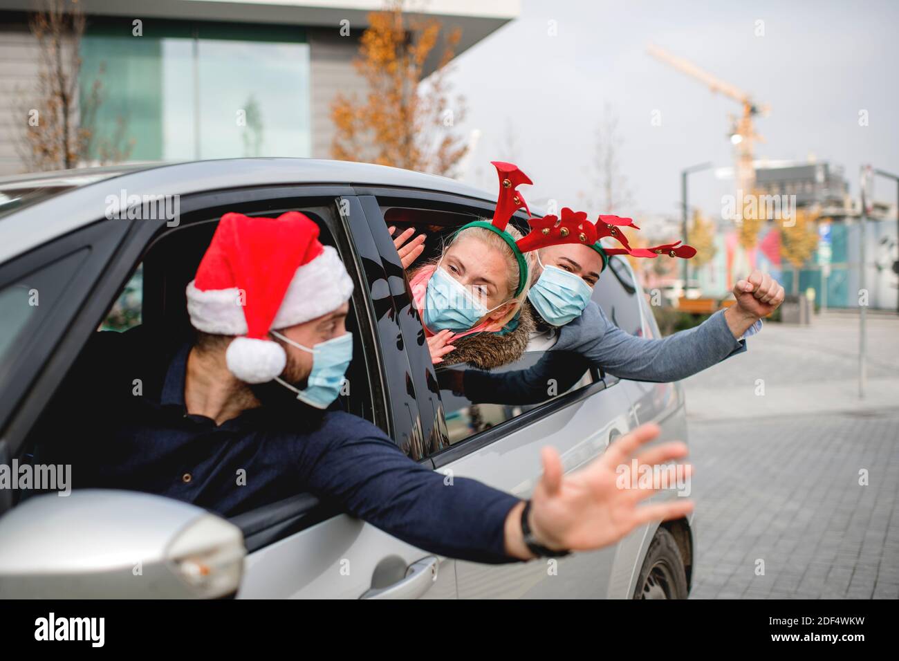 Friends wearing a protective face mask in the car. Holidays during