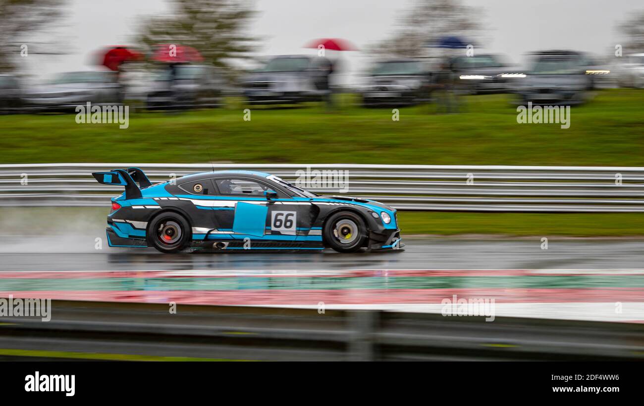 A panning shot of a racing car as it circuits a track. Stock Photo