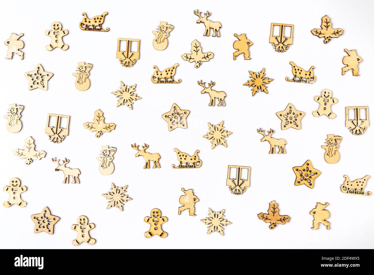 a texture formed by small wooden Christmas icons on a white background Stock Photo