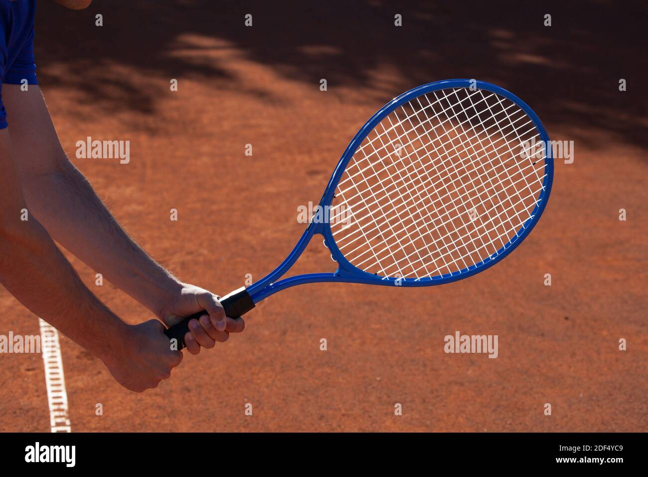 Tennis player holding a tennis racket in two hands in an expectation of the service of the opponent Stock Photo
