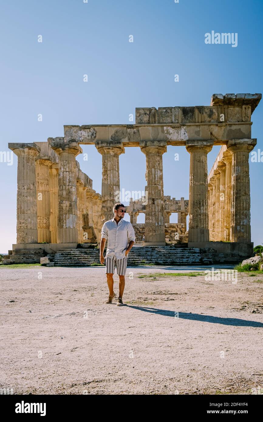 A guy visit Greek temples at Selinunte during vacation, View on sea and ruins of greek columns in Selinunte Archaeological Park Sicily Italy Stock Photo