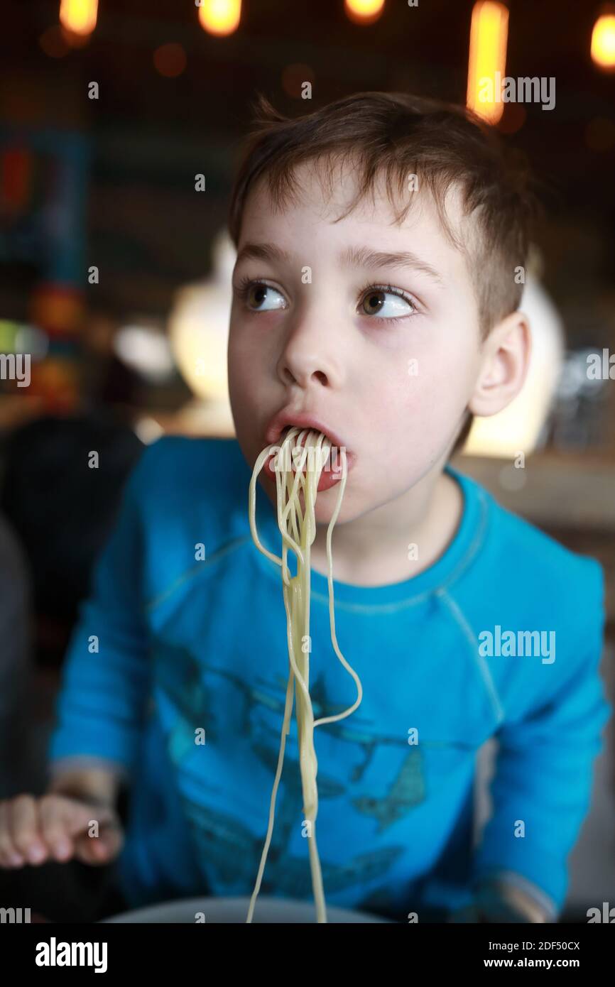 Kid eating spaghetti in an italian restaurant Stock Photo Alamy
