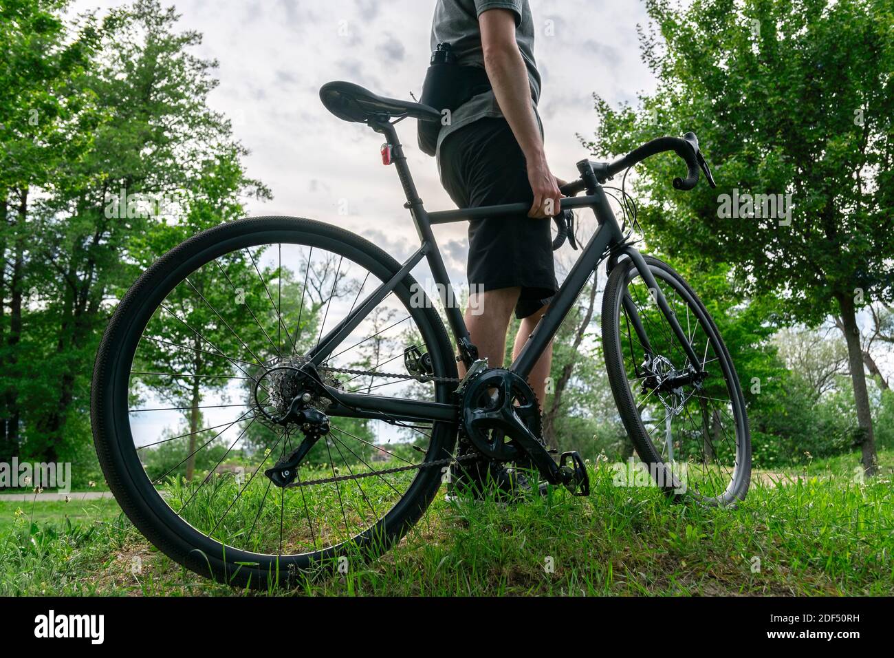 Man athletic figure with gravel bike in the nature. Traveling on bicycle. Stock Photo