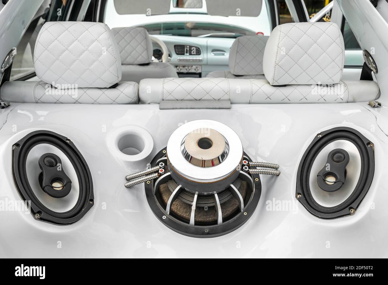 Tuned car with powerful audio system and sub woofers in the car trunk. Custom white car interior. Stock Photo
