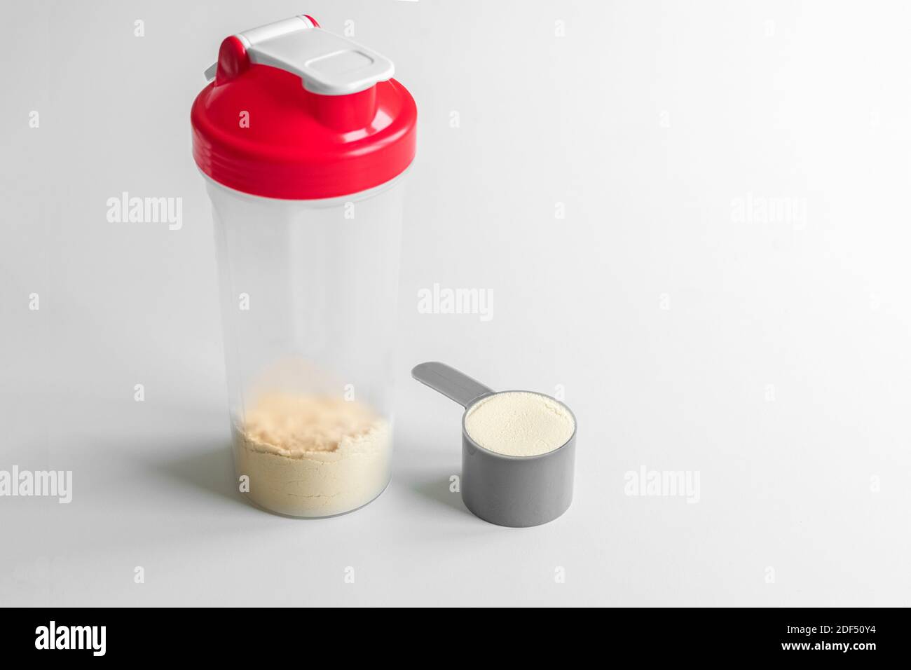 Vanilla whey protein scoop. Sports nutrition. Whey protein shaker on white backgrouns. Stock Photo