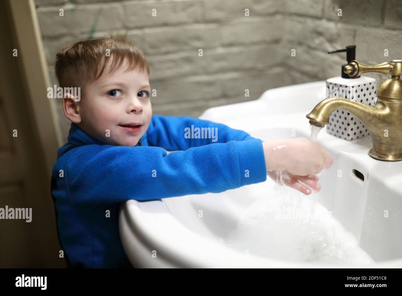 Kid washing his hands in a restroom Stock Photo Alamy
