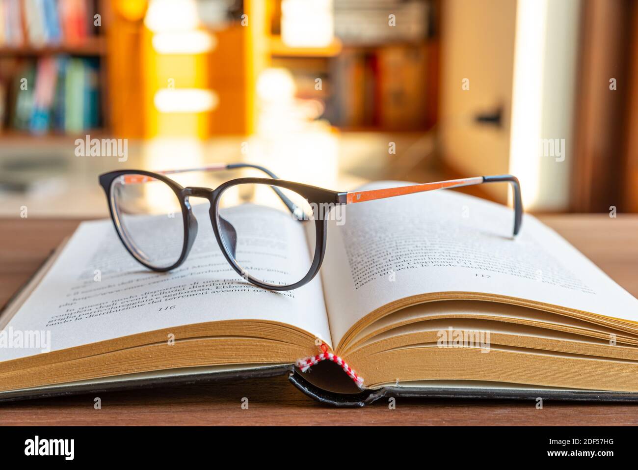 Open book, with eyeglasses on top Stock Photo Alamy