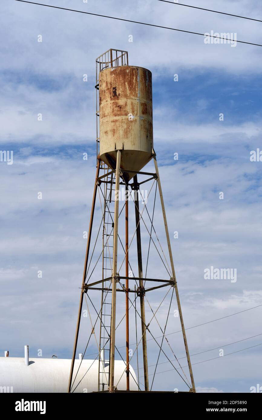 A vertical shot of an old, rusty water tower against a cloudy sky Stock ...