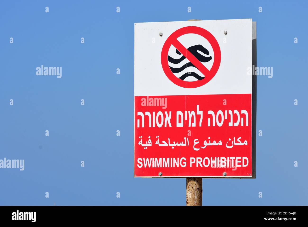 Signboard on Tel Aviv urban beach warning that swimming is prohibited. Stock Photo